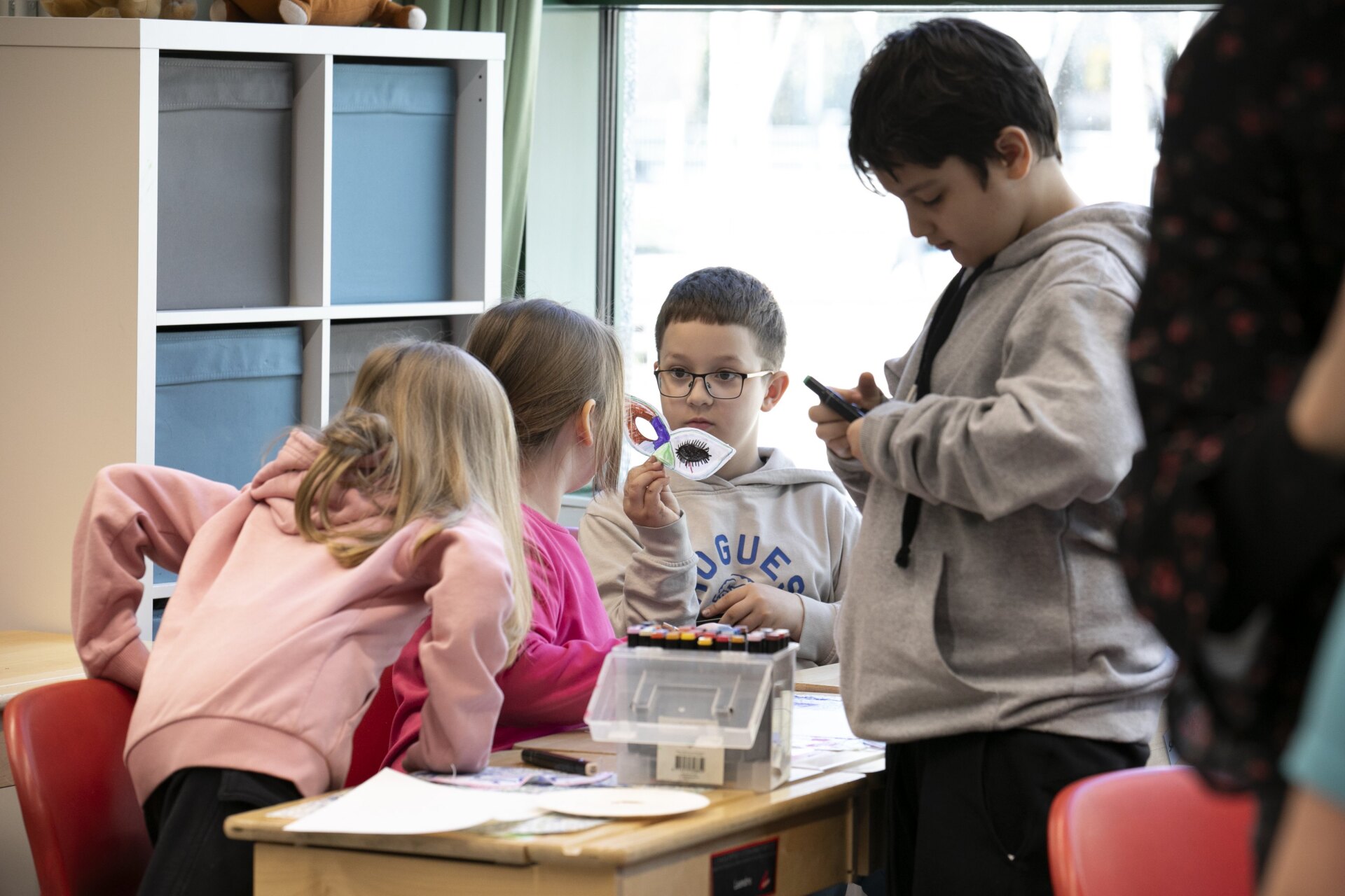 Lapset askartelevat luokassa.